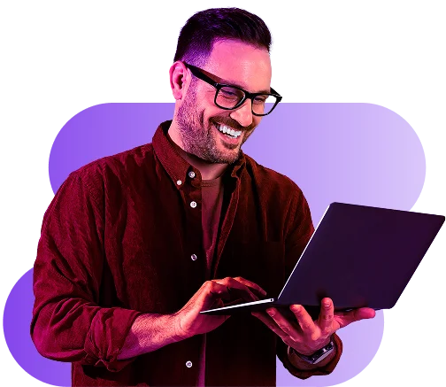 Happy professional man using laptop with purple lighting background symbolizing seamless digital work.