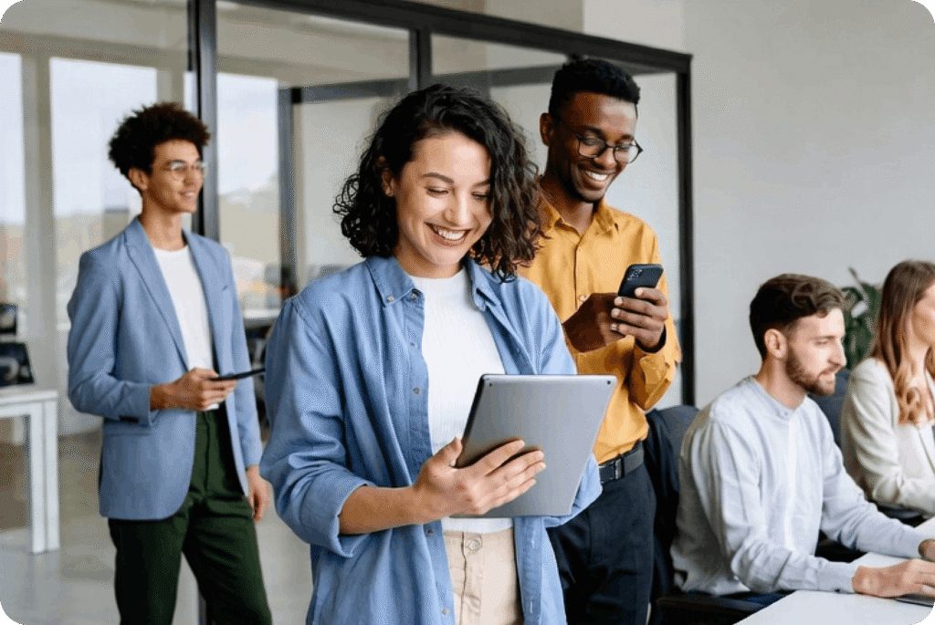 Business team using tablet and smartphones in office environment, representing bulk digital gift card distribution for enterprises and B2B platforms.